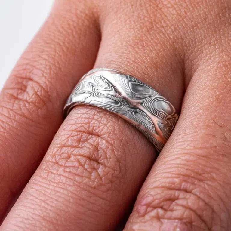 mokume gane patterned ring made to resemble rocky terrain, with a vein of red gold running through the ring in contrast to the silver