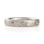 light silvery colored mokume gane ring made in woodgrain pattern with surface carving for added texture