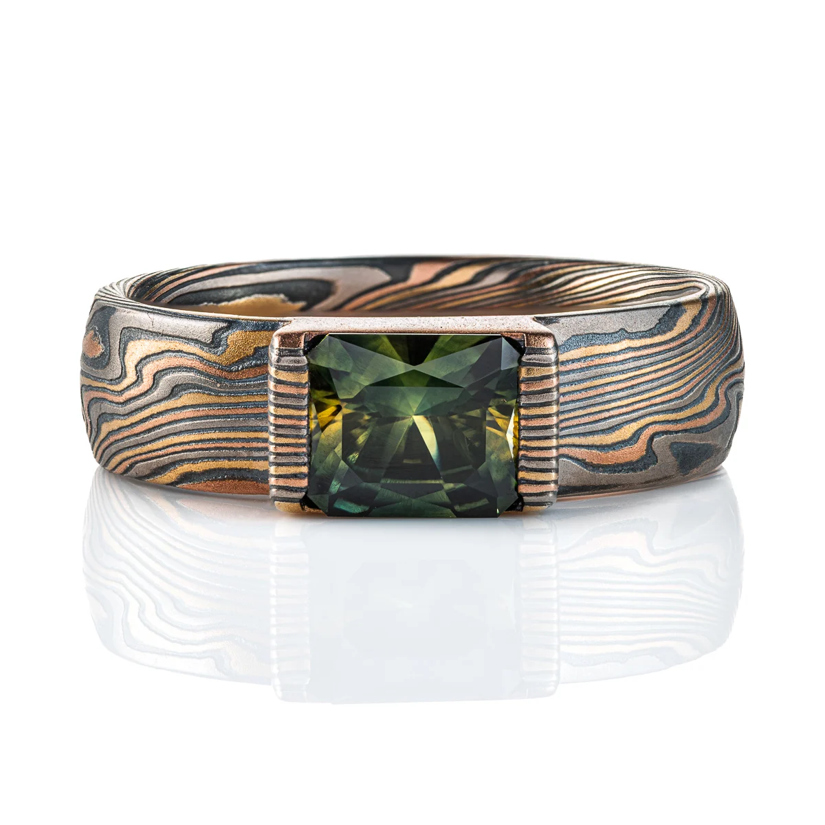 mokume gane ring with multicolored layers of metals, with a large dark green stone set into it