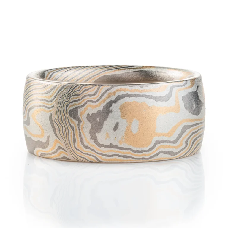 extra wide mokume gane band made in twisted pattern and a combination of yellow gold, palladium and silver, with a low domed profile and smooth finish