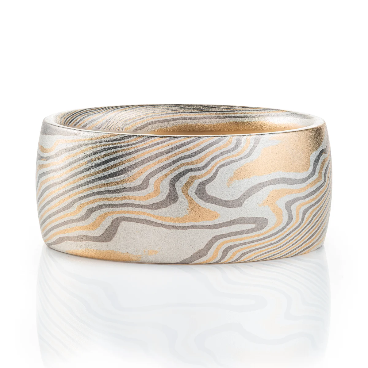 extra wide mokume gane band made in twisted pattern and a combination of yellow gold, palladium and silver, with a low domed profile and smooth finish