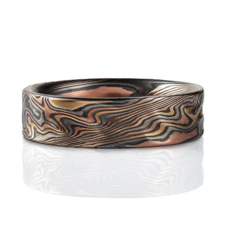 Twisting mokume gane pattern ring in multicolor palette with surface texture.