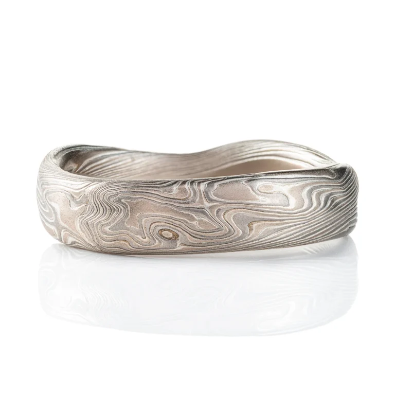 Flat profile band made in mokume twist style pattern, with added surface carving and etched finish for a bumpy texture.