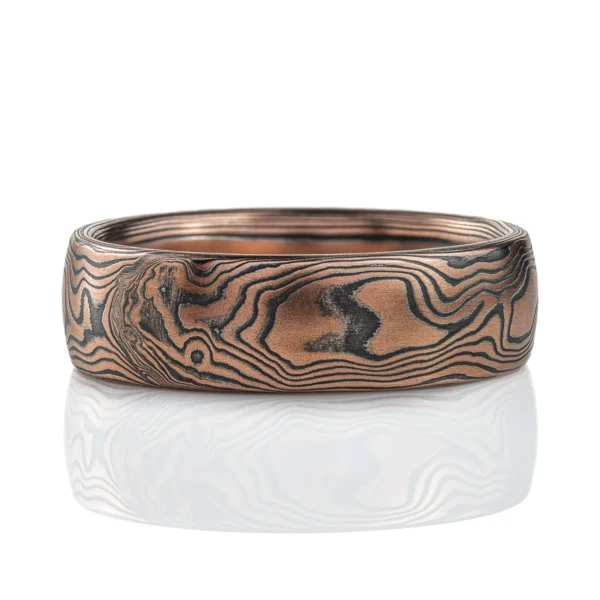 Rustic feeling mokume gane band made with red gold and oxidized silver, in a woodgrain pattern.