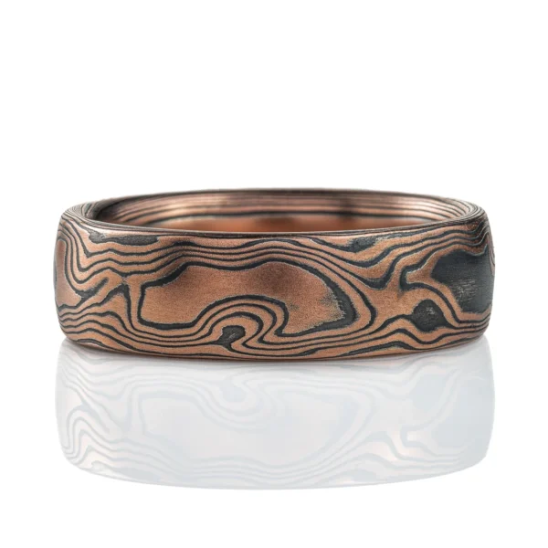 Rustic feeling mokume gane band made with red gold and oxidized silver, in a woodgrain pattern.