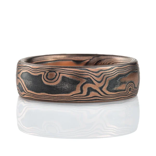 Rustic feeling mokume gane band made with red gold and oxidized silver, in a woodgrain pattern.