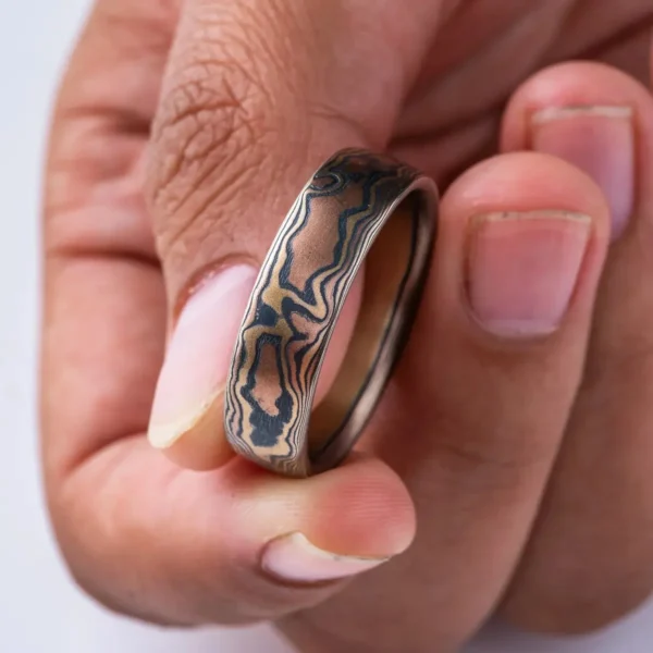 mokume gane woodgrain style patterned ring, made with red gold, yellow gold and oxidized silver