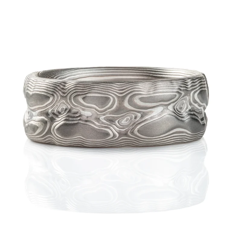 Ring patterned in a topographic style that resembles rocks and mountains, silver and light gray color combination.