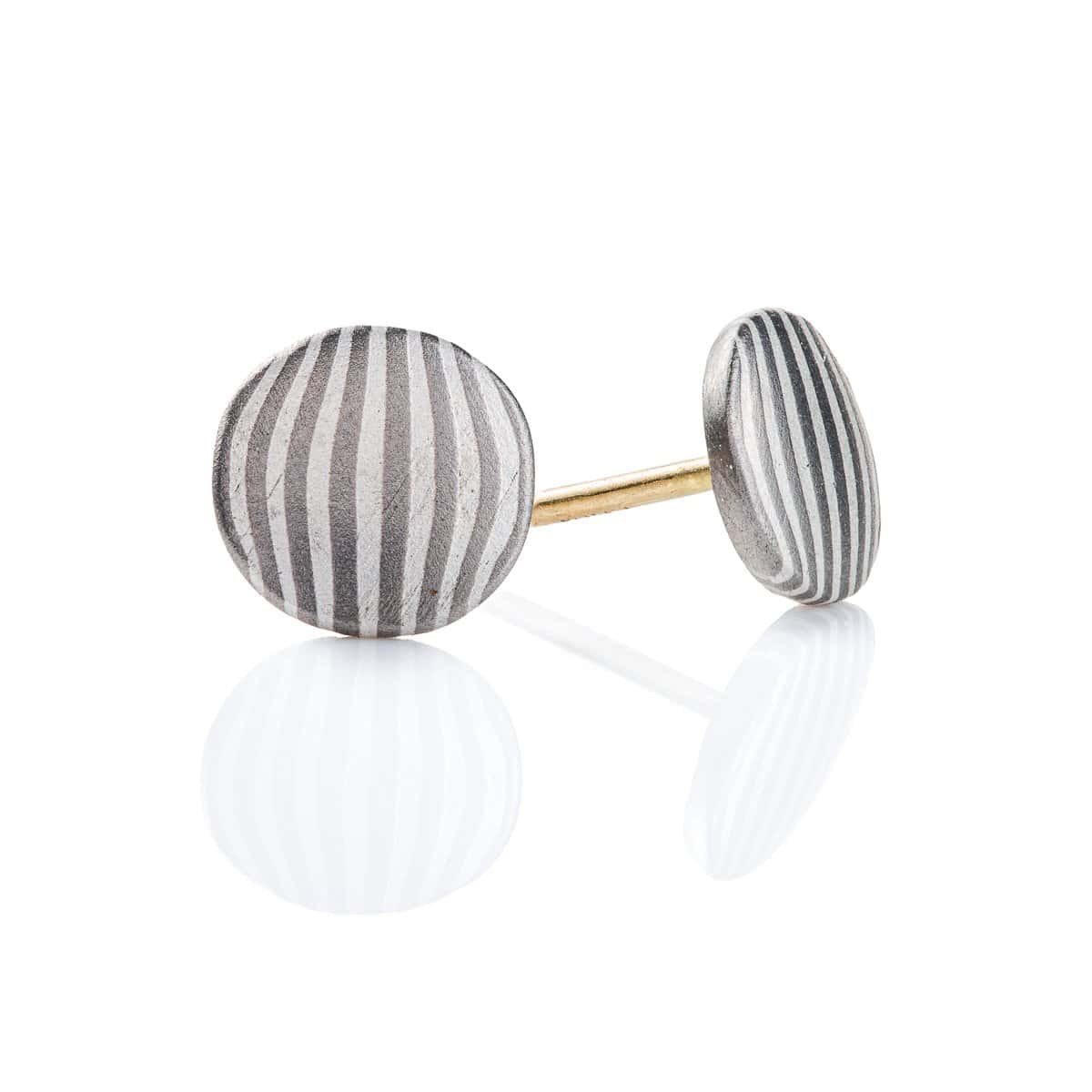 Small round mokume gane stud earrings, striped with dark and light gray, made with palladium and silver.