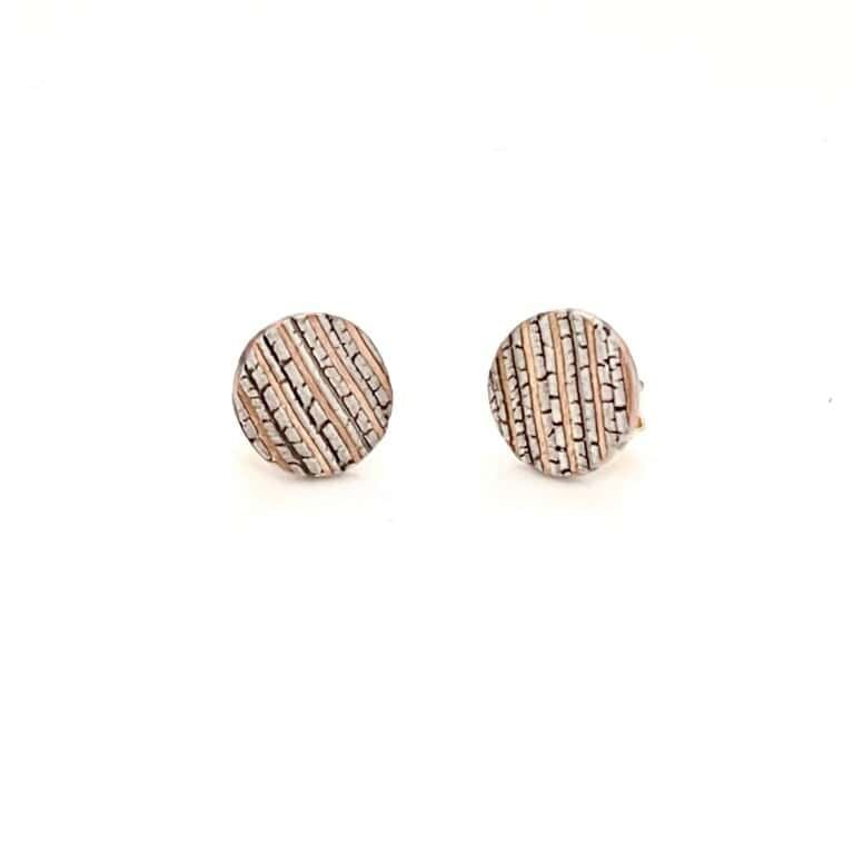 circle shaped stud earrings, made of stripes of red gold, palladium and oxidized silver with a crackled texture