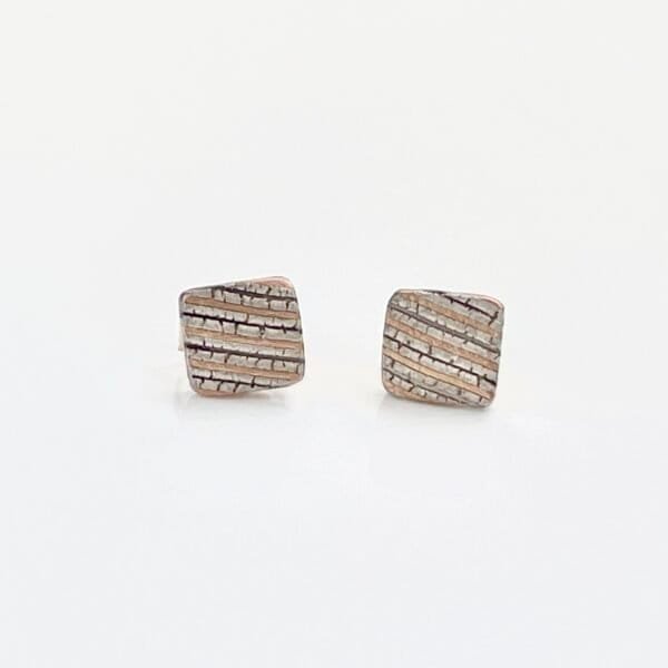 square mokume gane stud earrings are made in our Embers palette, featuring 14kt red gold, palladium, and silver. They feature an etched and oxidized finish and added texture for a rustic feel.