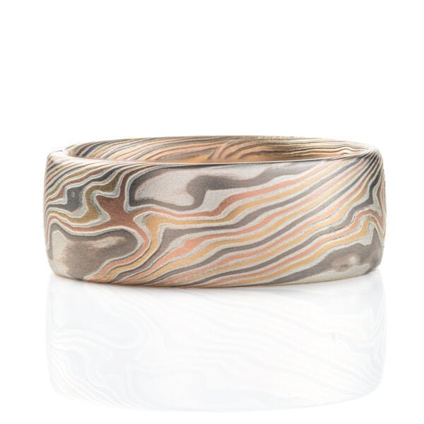 Two mokume gane rings, made in matching pattern and color combinations, with the same widths and similar ring sizes. Both rings made with red gold, yellow gold, palladium and silver.