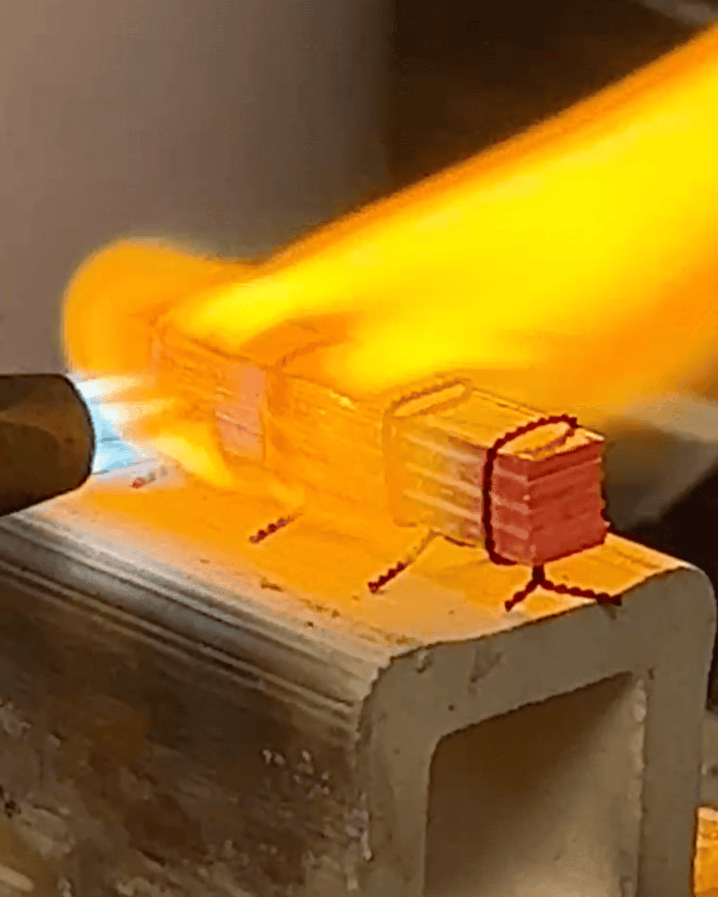 A metal billet being torch fired.