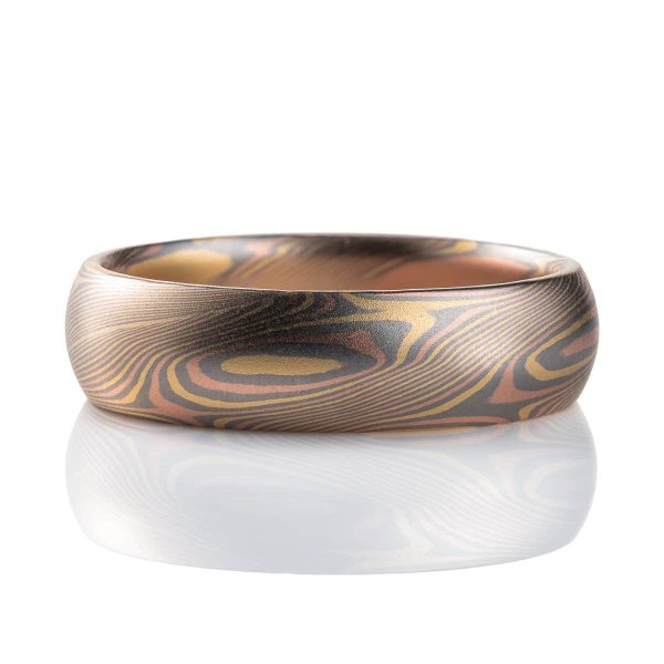 Slim mokume gane patterned ring with angled ellipse shapes running around the band, made with red gold, yellow gold and palladium, domed profile, smooth finish.