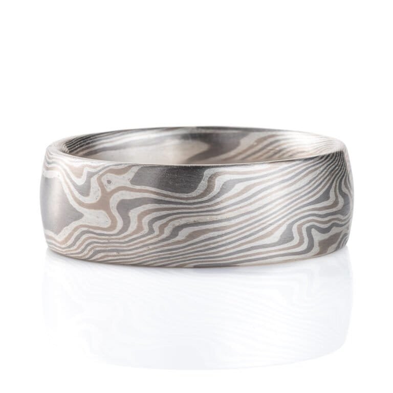 Wide, smooth finish mokume gane patterned ring, made with three different metal colors, ranging from light to dark gray.