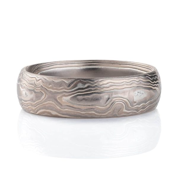 Very textured woodgrain patterned mokume gane band, made of different layers of shades of gray. Texture resembles rippling water.