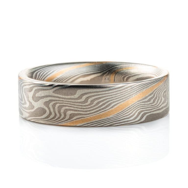Flat profile ring made in mokume gane twist pattern, with layers of light and dark gray metals, and one layer of yellow gold.