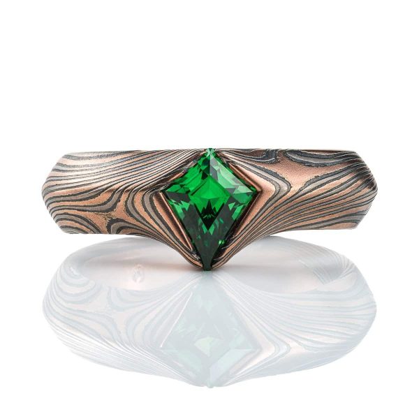 Statement mokume gane ring made with red gold, palladium and oxidized silver, with a bright green kite shaped stone, the band wraps around the long point of the stone.
