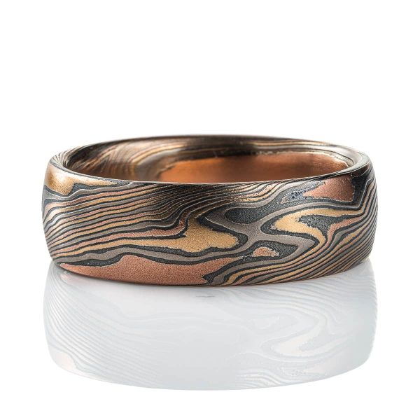 Mens mokume gane band made in twist pattern, with layers of red gold, yellow gold, palladium, and oxidized silver (black). .