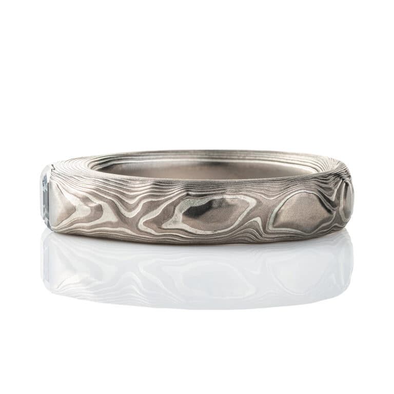 Textured mokume gane patterned ring, with three dimensional carving made to resemble rock. The ring is slightly thicker towards the top, to hold an asscher cut diamond that has been set flush into the ring.