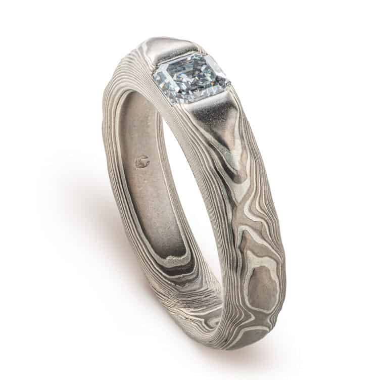 Textured mokume gane patterned ring, with three dimensional carving made to resemble rock. The ring is slightly thicker towards the top, to hold an asscher cut diamond that has been set flush into the ring.
