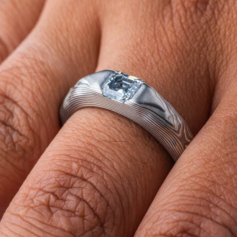 Textured mokume gane patterned ring, with three dimensional carving made to resemble rock. The ring is slightly thicker towards the top, to hold an asscher cut diamond that has been set flush into the ring.