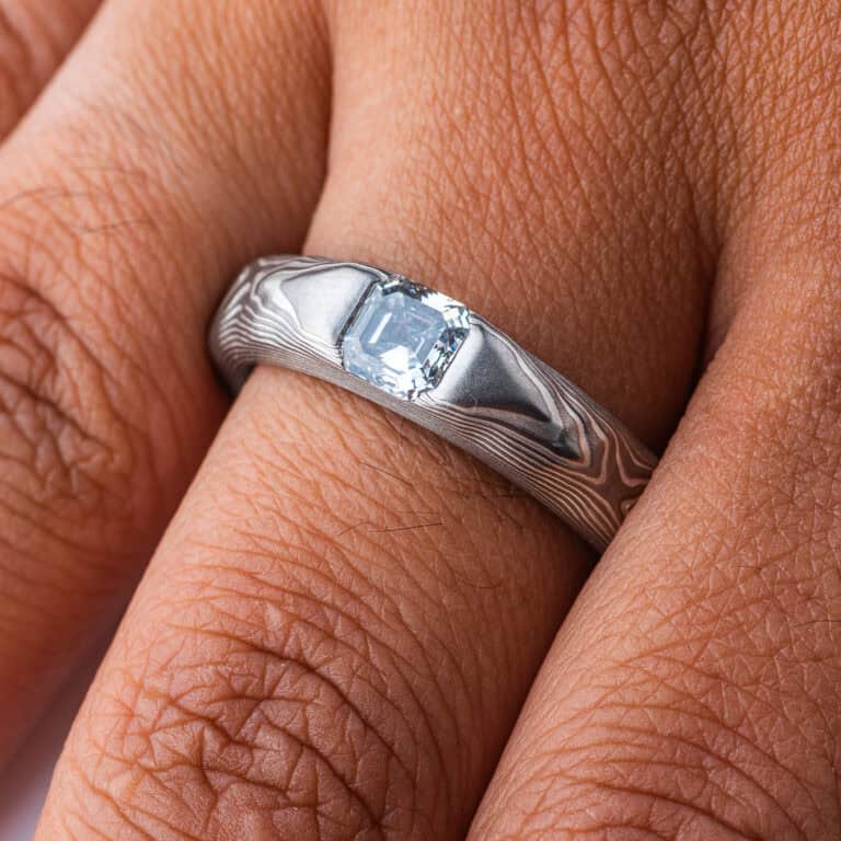 Textured mokume gane patterned ring, with three dimensional carving made to resemble rock. The ring is slightly thicker towards the top, to hold an asscher cut diamond that has been set flush into the ring.