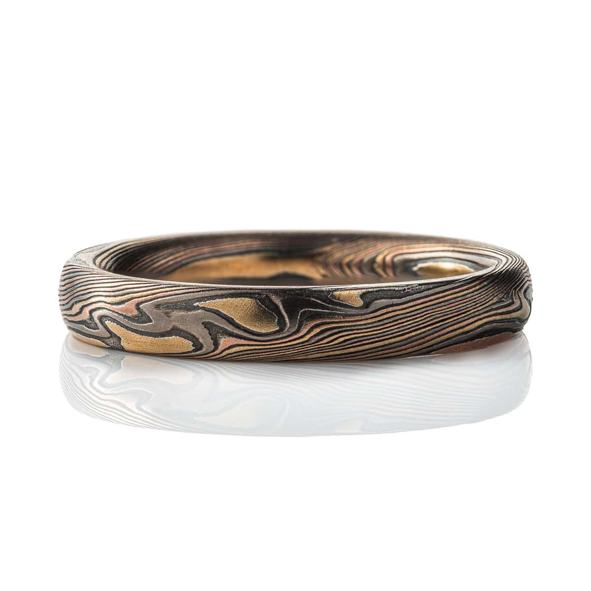 Narrow mokume gane patterned band, made with red gold, yellow gold, palladium and oxidized silver.