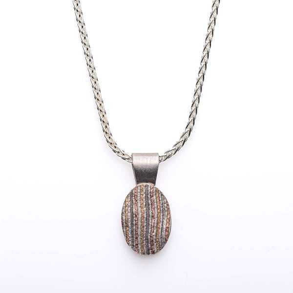 Small oval shaped mokume gane patterned pendant. Hanging on a silver chain.