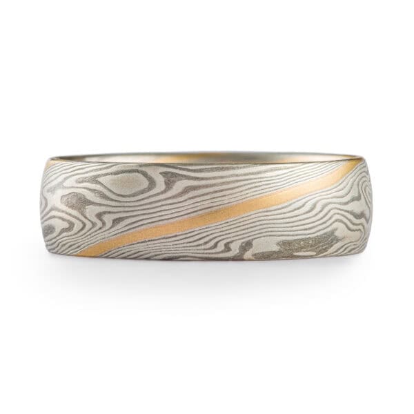 Mokume gane ring made in twist pattern, made of shibuichi and silver, with a single stripe of yellow gold.