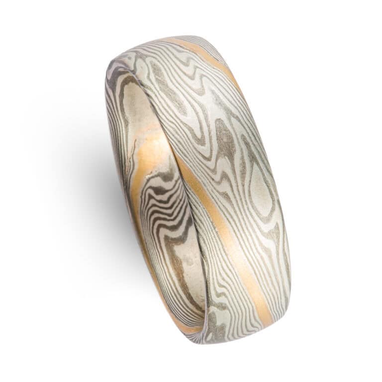 Mokume gane ring made in twist pattern, made of shibuichi and silver, with a single stripe of yellow gold.