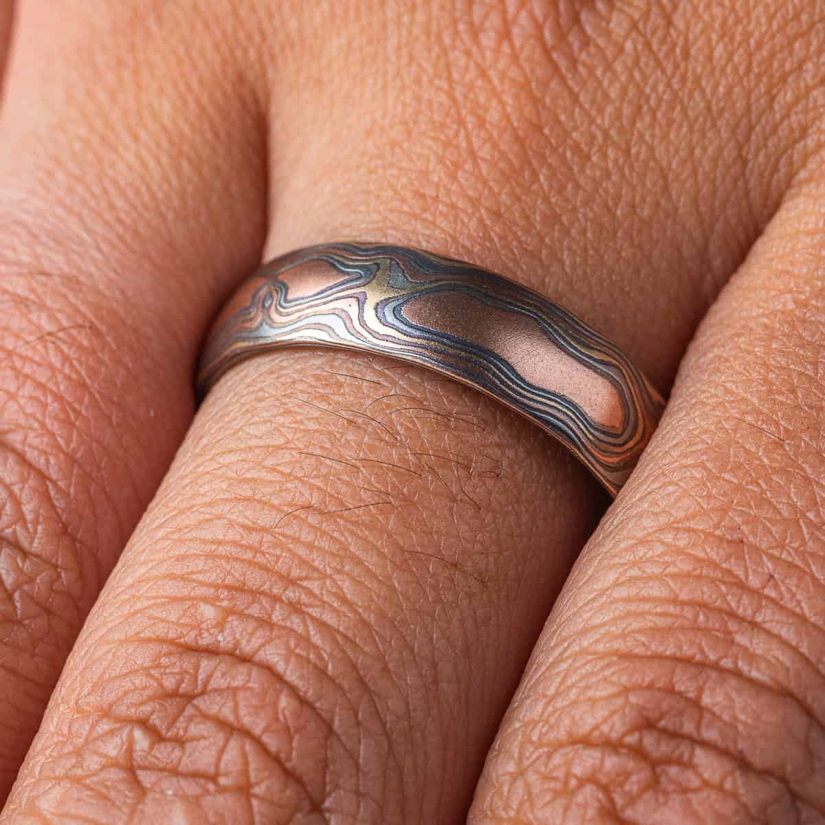 Mens style mokume gane woodgrain patterned band, made with red gold, yellow gold, palladium and silver.