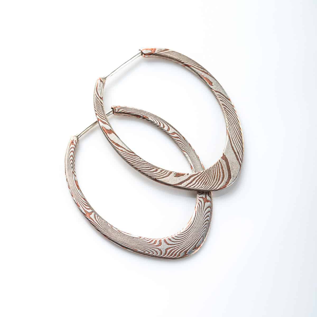 pair of mokume gane patterned hoops, flat profile, apogee shape, made with copper and silver