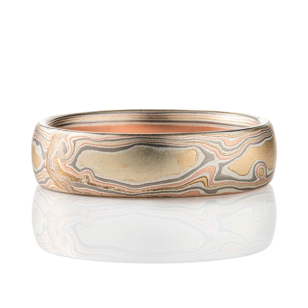 Slim mokume gane patterned band, twisting and organic flowing pattern, made with layers of red gold, yellow gold, palladium, and etched silver.