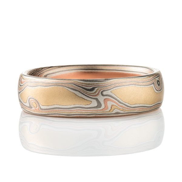 Slim mokume gane patterned band, twisting and organic flowing pattern, made with layers of red gold, yellow gold, palladium, and etched silver.