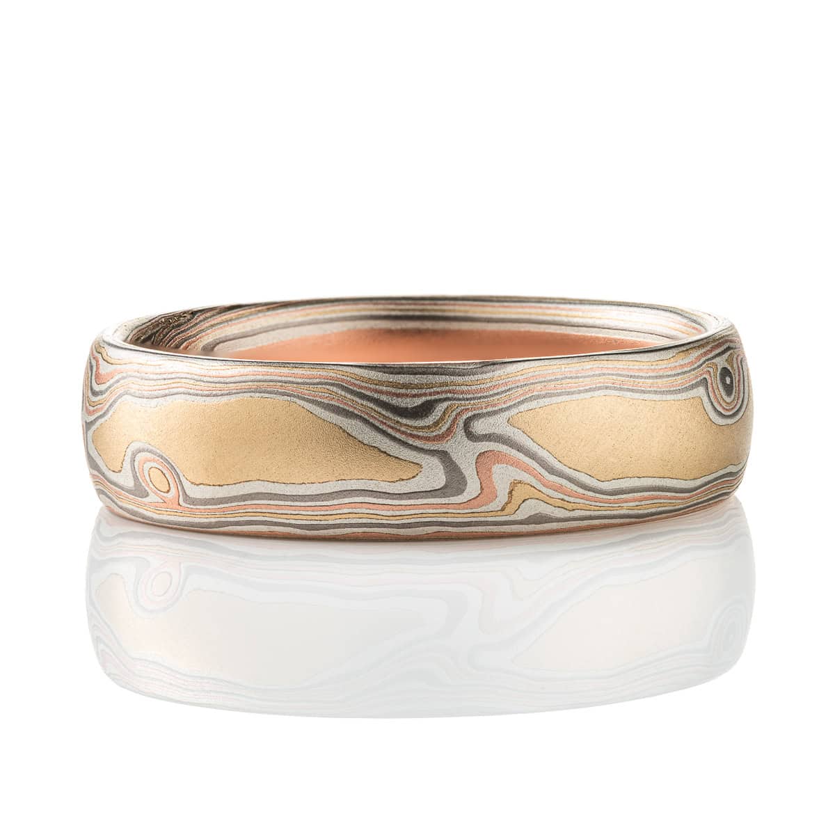 Slim mokume gane patterned band, twisting and organic flowing pattern, made with layers of red gold, yellow gold, palladium, and etched silver.