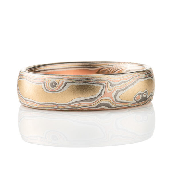 Slim mokume gane patterned band, twisting and organic flowing pattern, made with layers of red gold, yellow gold, palladium, and oxidized silver.