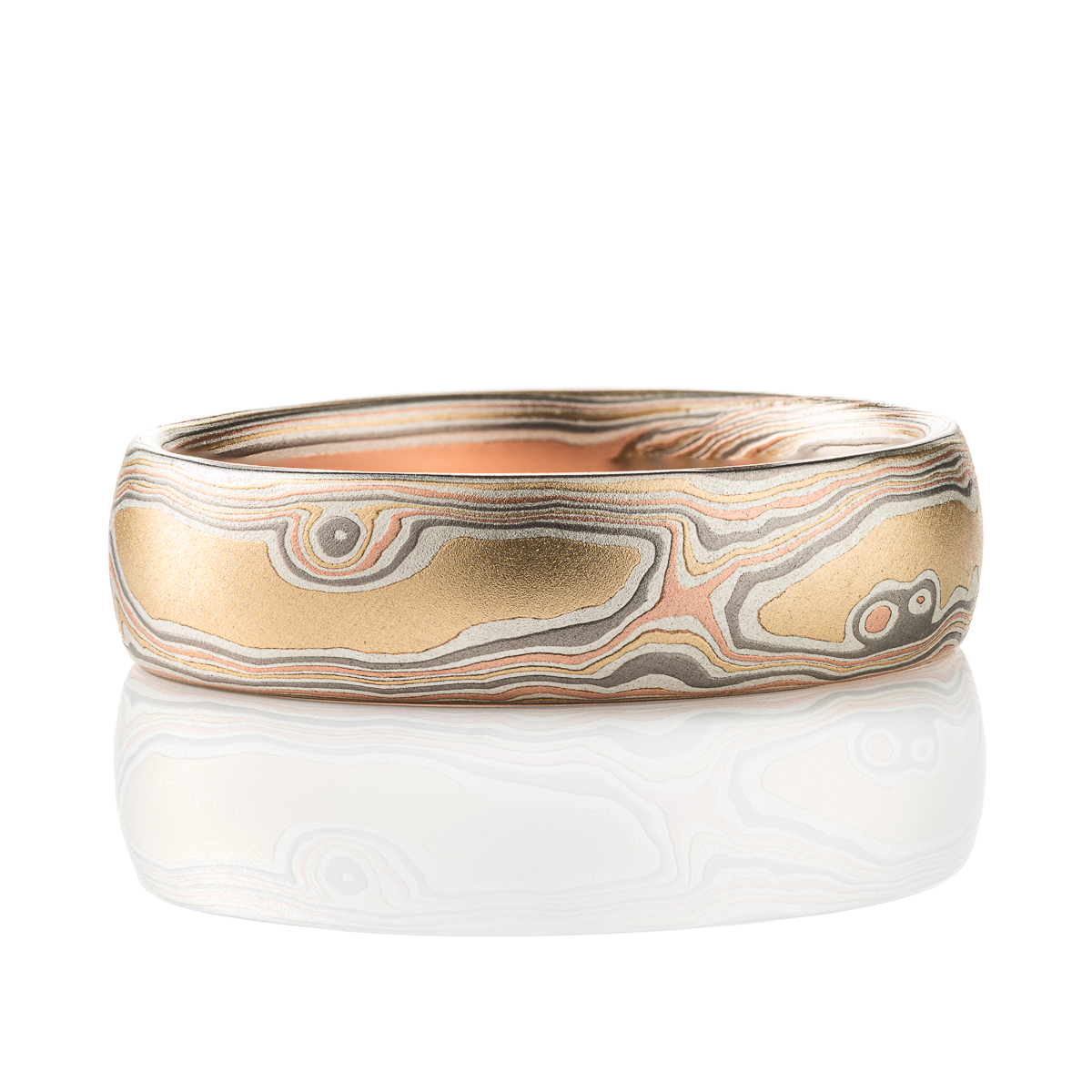 Slim mokume gane patterned band, twisting and organic flowing pattern, made with layers of red gold, yellow gold, palladium, and oxidized silver.