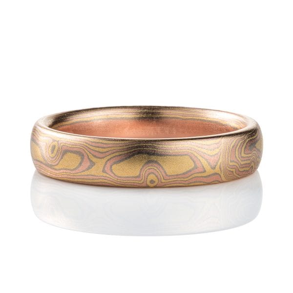 All gold mokume gane patterned band, made to resemble woodgrain, with layers of red and yellow gold with palladium in between.